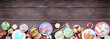 Cool summer food bottom border. Assorted ice cream, popsicles and frozen treats. Pastel colors. Top view on a dark wood banner background.