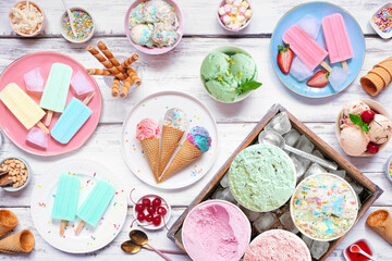 Poster - Cool summer food table scene. Variety of ice cream, popsicles and frozen treats. Pastel colors. Above view on a white wood background.