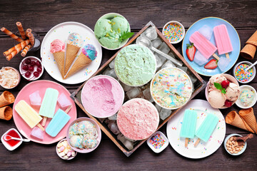 Poster - Cool summer food table scene. Different ice cream, popsicles and frozen treats. Pastel colors. Overhead view on a dark wood background.