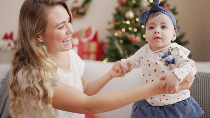 Sticker - Woman and toddler standing on sofa by christmas tree at home