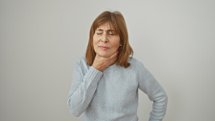 Sticker - Mature woman in discomfort holding her throat against a white background expressing pain