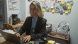 © Krakenimages.com - Caucasian woman detective working on laptop in cluttered police station office