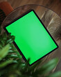 Tablet encima de la mesa con fondo verde croma.