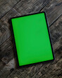 Tablet encima de la mesa con fondo verde croma.