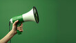 © P - A hand is shown holding a megaphone against an green background, symbolizing communication or announcement. The image is dynamic and attention-grabbing, with copy space