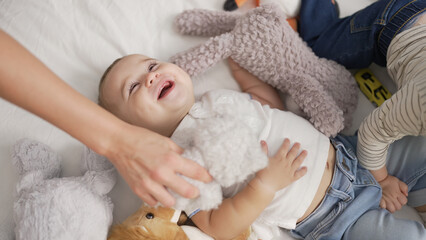 Sticker - Adorable toddler smiling confident lying on bed with dolls at bedroom