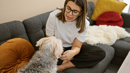 Canvas Print - A young woman interacts affectionately with a fluffy dog in the cozy setting of a modern living room.