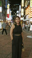 Sticker - Beautiful hispanic woman's serious expression captured in cityscape portrait, standing strong on tokyo's urban streets under illuminating night lights