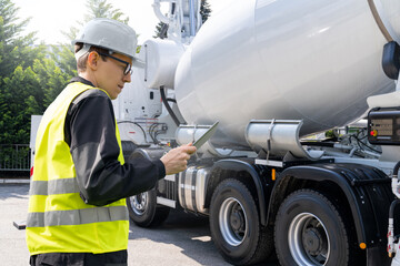 Poster - Worker with digital tablet next to truck-mounted concrete pump with mixer