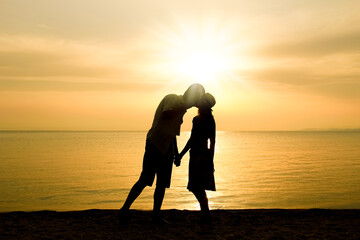 Wall Mural - A happy couple by the sea on nature in travel silhouette