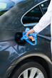 Man holds a hydrogen fueling nozzle. Refueling car with hydrogen fuel. Concept