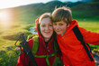 Portrait of happy mother and son tourists in a picturesque mountain valley at sunset