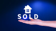 Realtor's hand puts with icon house and word SOLD. Concept of selling house, apartment, real estate. market of immobility, Property investment and house mortgage financial concept
