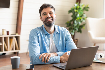 Aufkleber - A man is sitting at a desk, facing a laptop computer with a serious expression. He is typing on the keyboard, seemingly focused on his work or task at hand.