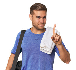 Athlete with gym bag, studio showing number one with finger.