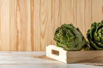 Wall Mural - Ripe organic artichokes on a white wooden table. Vegetable background.