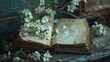 Antiquated Open Book With Pages, Surrounded by White Flowers and Leaves, Set Against Distressed Rustic Wall Background.