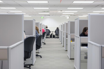 Aufkleber - a row of cubicles where workers diligently multitask, fielding phone calls, responding to emails, an