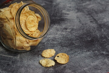 Emping, Indonesian traditional snack made from melinjo or belinjo seeds. Bitter and savory. served on transparent food container with black background