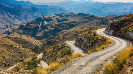 Poster - A winding mountain road disappearing into the horizon, offering a scenic drive through rugged terrain.