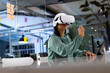© Wavebreak Media - Biracial businesswoman in VR headset touches air, working late at office