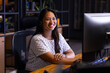 © Wavebreak Media - Biracial businesswoman in headset reviews screen, working late at office