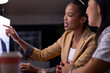 © Wavebreak Media - At office, diverse female colleagues examining sales data, working late