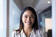 © Wavebreak Media - Biracial middle-aged woman with dark hair, brown eyes, smiles at camera in office