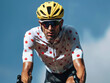 dynamic cyclist in tour de france competition attire racing against a clear blue sky, wearing the mountain king jersey