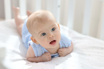 Canvas Print - Cute little baby lying in crib at home, space for text