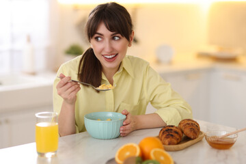 Sticker - Smiling woman eating tasty cornflakes at breakfast indoors