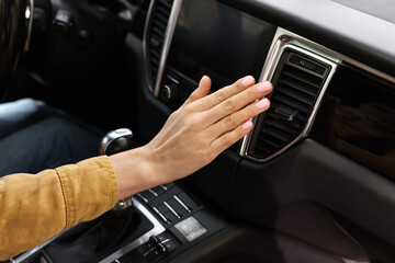 Wall Mural - Woman checking air conditioner in her car, closeup