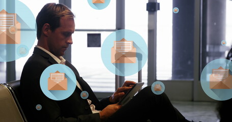 Poster - Image of message icons floating over caucasian businessman using digital tablet at an airport