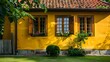 © asma - Charming yellow house with wooden windows and green grassy garden