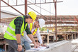 © JU.STOCKER - Engineer and foreman worker team checking project at precast factory site, Engineer and builders in hardhats discussing on construction site