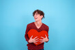 Valentine's Day Funny guy posing in the studio. Blue background.