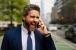 Anger Businessman with phone outdoor. Angry Business talk. Anger Man walk down street talking on the phone. Stressed Man in suit screaming on the phone. Angry man shouting at his smartphone.