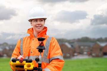 Cheerful professional Female site engineer surveyor working with theodolite total station EDM equipment at construction site	