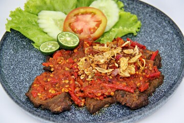 Empal Penyet consists of deep-seated beef cooked with kitchen spices such as bay leaves, galangal, lime leaves, tamarind, shallots, garlic, and many more.