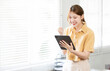 Happy relaxed young woman standing in home office using tablet, excited lady laughing holding tablet, enjoying doing online ecommerce shopping in mobile apps