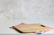 mockup of an empty cutting board and a checkered towel on the table. kitchen background.