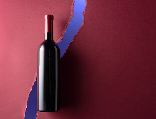 Wall Mural - Bottle of red wine on a dark red background.