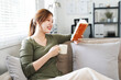 Young woman  wear t-shirt drink coffee and read book  sits in couch stay at home flat rest relax spend free spare time in living room