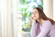 Woman relaxing sitting on a sofa with closed eyes at home