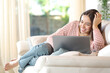 Happy woman using laptop on a sofa