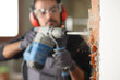 Construction worker using a rotary hammer to wreck a wall