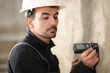 Construction worker using a digital distance meter