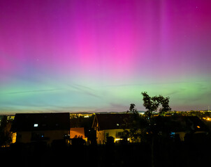 Wall Mural - northern lights over the city in the night in germany