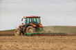 A modern tractor tilling farmland, preparing the soil for planting crops