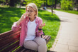 Portrait of mature woman in park. She is talking on phone.